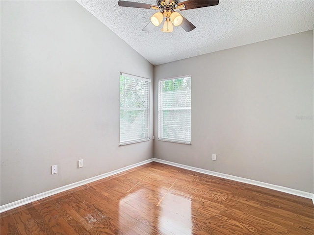 unfurnished room featuring hardwood / wood-style floors, ceiling fan, a textured ceiling, and lofted ceiling