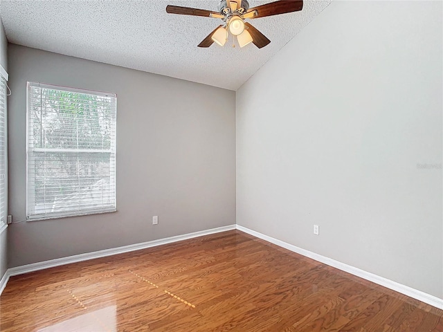 spare room with hardwood / wood-style floors, lofted ceiling, a textured ceiling, and ceiling fan