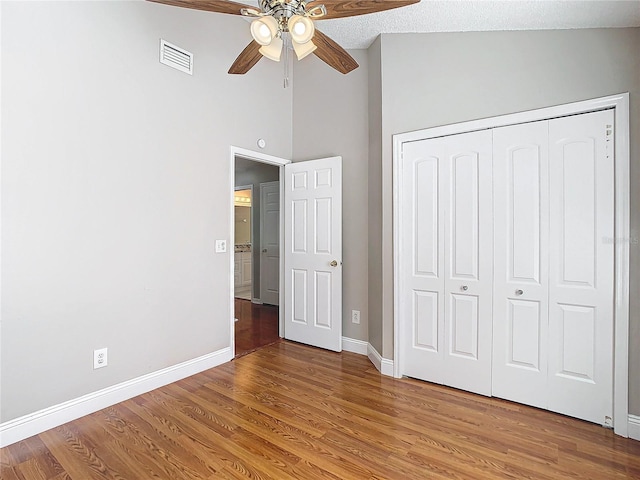 unfurnished bedroom featuring a textured ceiling, hardwood / wood-style floors, ceiling fan, and a closet