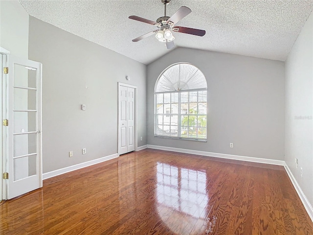 unfurnished room featuring hardwood / wood-style floors, lofted ceiling, a textured ceiling, and ceiling fan