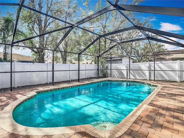 view of swimming pool featuring a lanai and a patio area