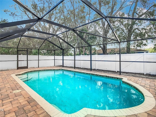 view of pool featuring glass enclosure and a patio