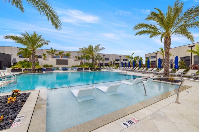 view of swimming pool featuring a patio and a hot tub