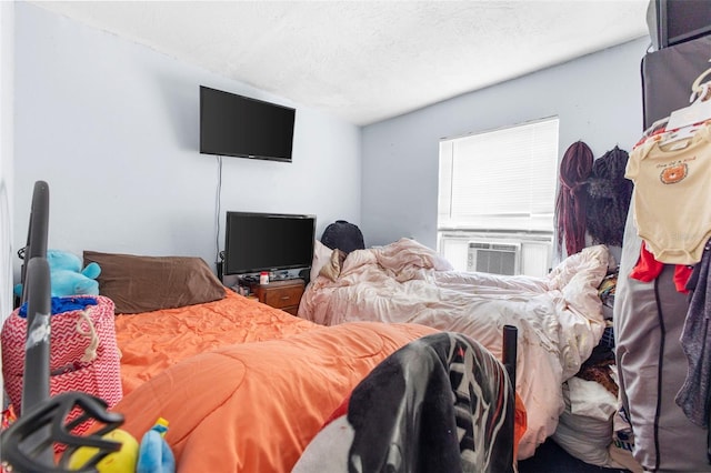 bedroom featuring cooling unit and a textured ceiling