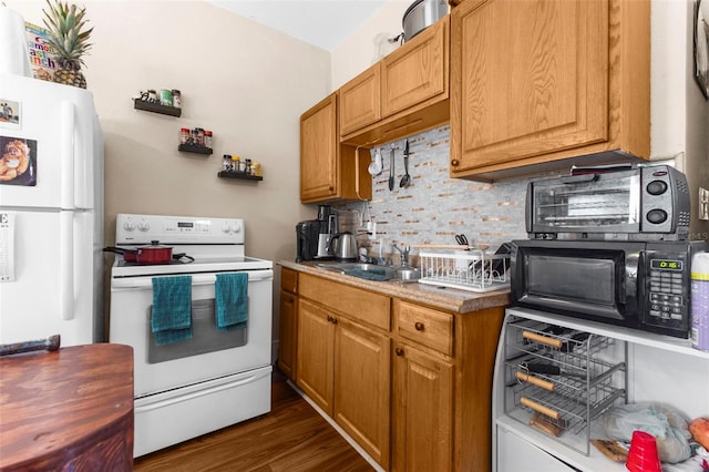 kitchen featuring dark wood-type flooring, sink, white appliances, and backsplash