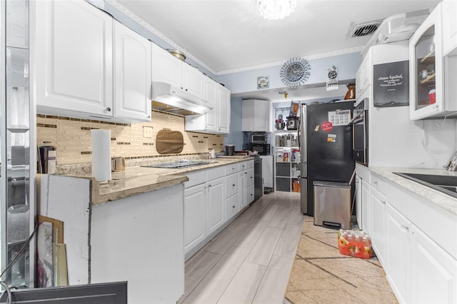 kitchen featuring black appliances, light stone countertops, sink, decorative backsplash, and white cabinets