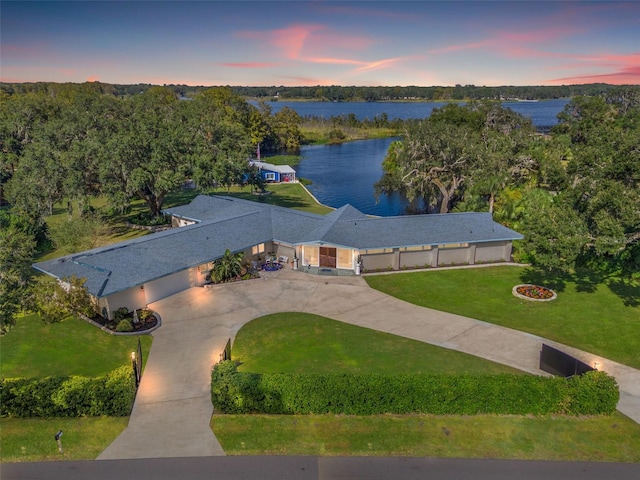 aerial view at dusk featuring a water view