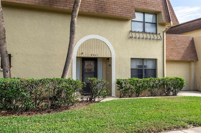 entrance to property with a lawn and a garage