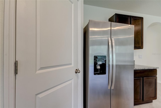33351 Apricot Tree Ct, Wesley Chapel, FL 33543 - kitchen with stainless steel refrigerator with ice dispenser, dark brown cabinetry, and light stone countertops