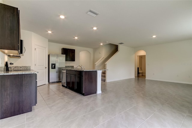 33351 Apricot Tree Ct, Wesley Chapel, FL 33543 - kitchen with stainless steel appliances, arched walkways, open floor plan, dark brown cabinets, and recessed lighting