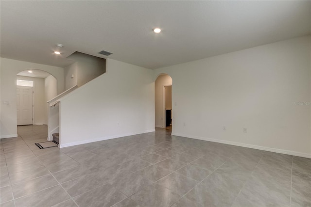 33351 Apricot Tree Ct, Wesley Chapel, FL 33543 - spare room featuring arched walkways, stairway, recessed lighting, and light tile patterned flooring
