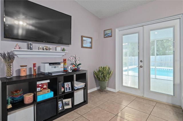 doorway featuring french doors, a textured ceiling, and light tile patterned flooring