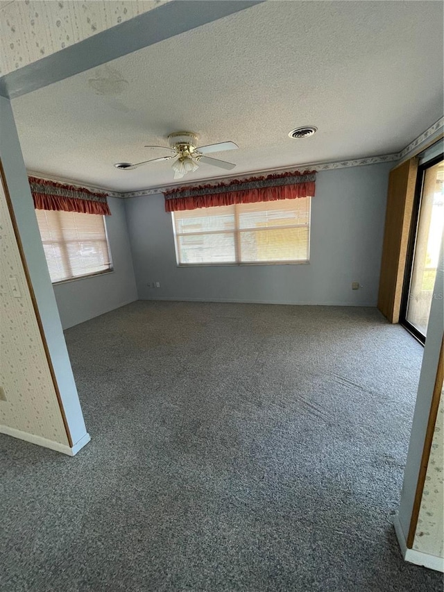 spare room with ceiling fan, a textured ceiling, and carpet floors