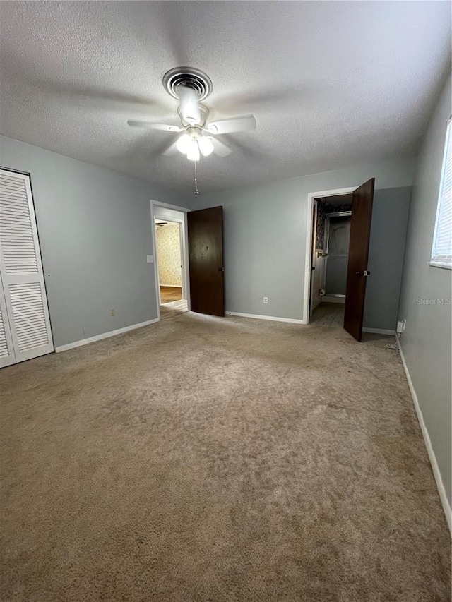 unfurnished bedroom featuring a textured ceiling, light colored carpet, ceiling fan, and a closet