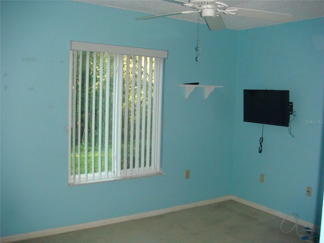 empty room with ceiling fan and a textured ceiling