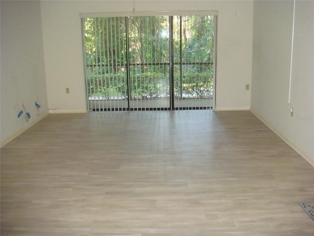 spare room featuring plenty of natural light and light hardwood / wood-style floors