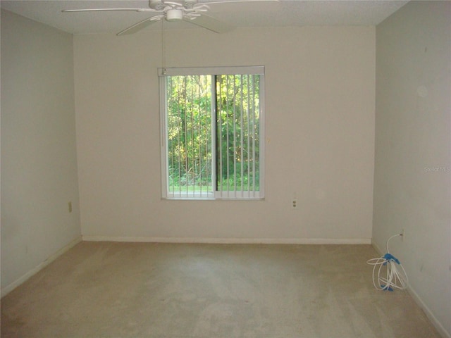 spare room with light colored carpet and ceiling fan