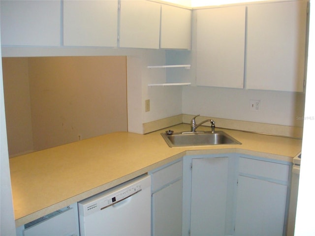 kitchen with dishwasher, white cabinetry, and sink