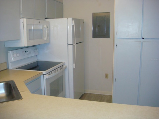 kitchen featuring hardwood / wood-style flooring, white appliances, sink, and electric panel