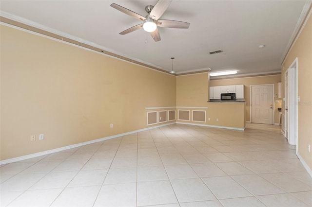 empty room with light tile patterned flooring, ceiling fan, and crown molding