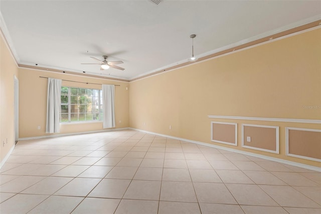 spare room featuring ceiling fan, crown molding, and light tile patterned floors