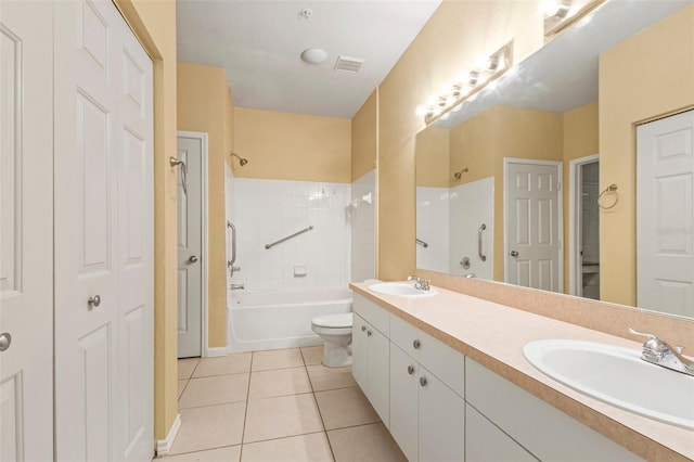 full bathroom featuring toilet, tiled shower / bath combo, vanity, and tile patterned flooring