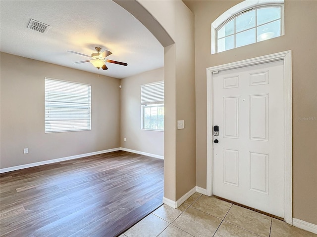 entryway featuring a textured ceiling, plenty of natural light, light hardwood / wood-style floors, and ceiling fan