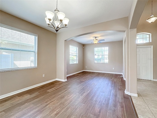 unfurnished room featuring light wood-type flooring and ceiling fan with notable chandelier