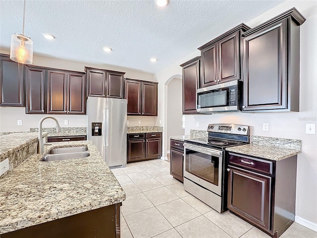 kitchen featuring decorative light fixtures, appliances with stainless steel finishes, sink, and a textured ceiling