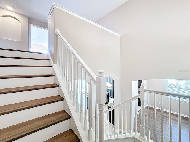 staircase featuring hardwood / wood-style floors and a chandelier