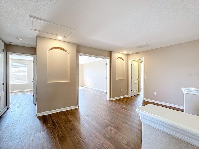 unfurnished room with wood-type flooring and a textured ceiling