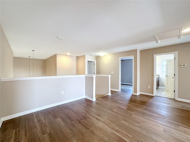 empty room with a textured ceiling and hardwood / wood-style flooring