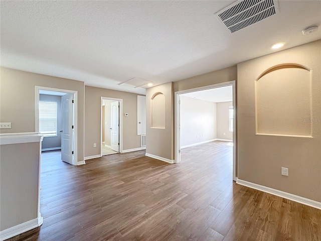 spare room with a textured ceiling and hardwood / wood-style flooring