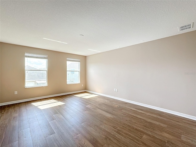 unfurnished room featuring hardwood / wood-style floors and a textured ceiling