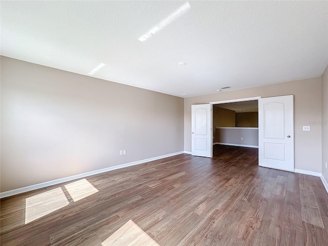 unfurnished room featuring hardwood / wood-style floors and a textured ceiling