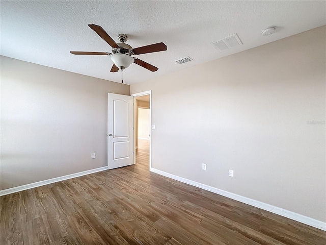 empty room with a textured ceiling, hardwood / wood-style flooring, and ceiling fan