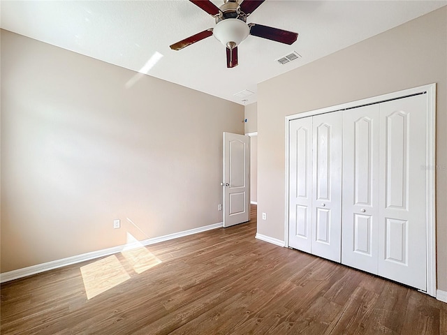 unfurnished bedroom with hardwood / wood-style floors, ceiling fan, and a closet