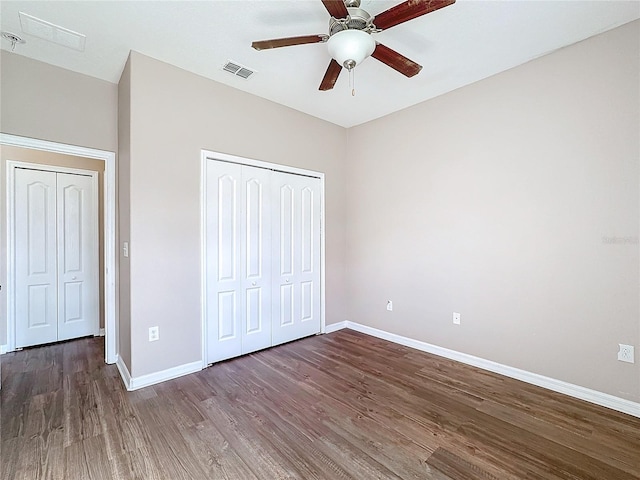 unfurnished bedroom featuring ceiling fan, dark hardwood / wood-style floors, and a closet