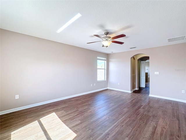 unfurnished room with a textured ceiling, dark hardwood / wood-style flooring, and ceiling fan