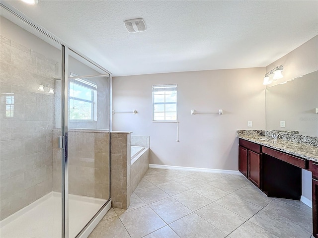 bathroom with vanity, independent shower and bath, tile patterned floors, and a textured ceiling