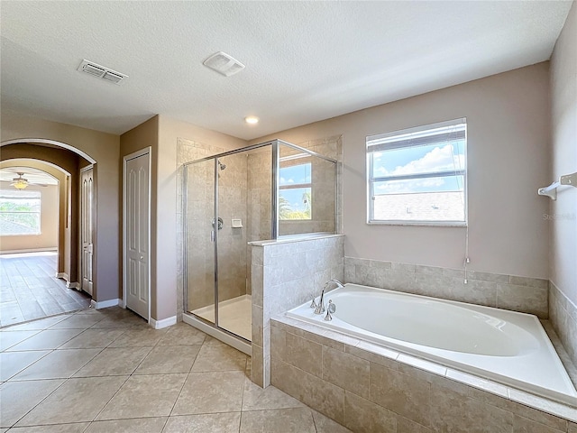 bathroom with a textured ceiling, tile patterned floors, ceiling fan, and separate shower and tub