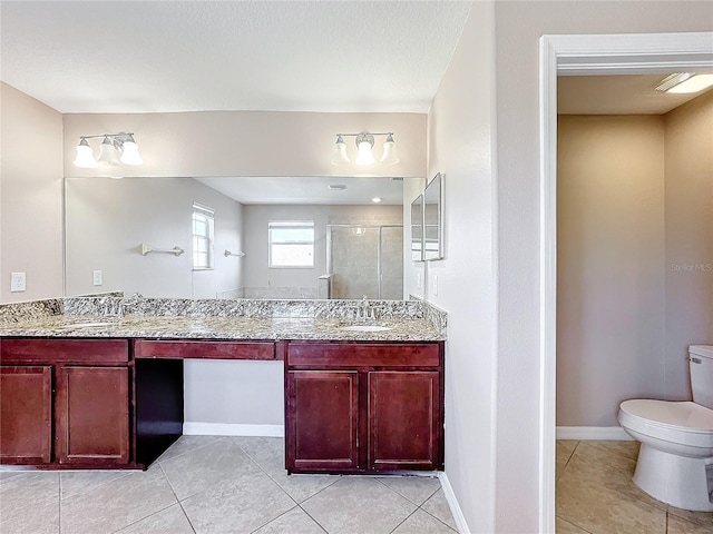 bathroom with toilet, tile patterned floors, vanity, and a shower with door