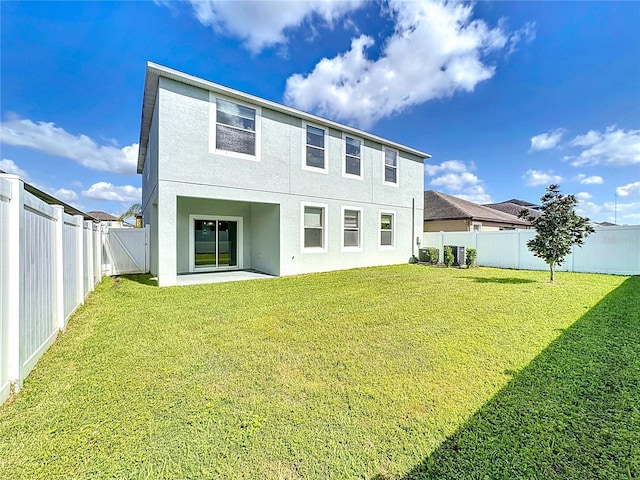 rear view of house with a lawn and a patio area