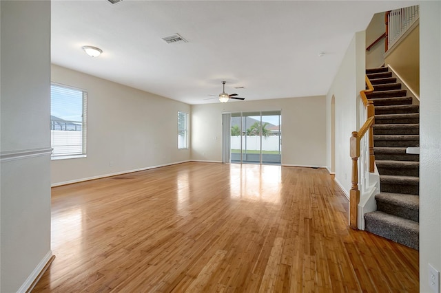 unfurnished living room featuring light hardwood / wood-style floors, ceiling fan, and plenty of natural light