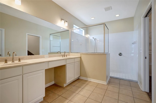 bathroom with tile patterned flooring, vanity, and a tile shower