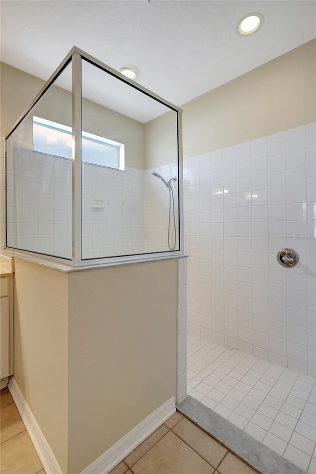 bathroom with vanity, tile patterned flooring, and tiled shower