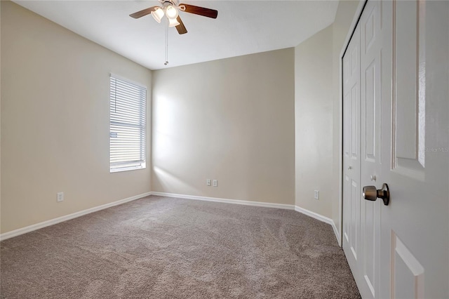 carpeted spare room with ceiling fan