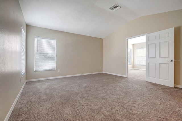 unfurnished room featuring vaulted ceiling and carpet flooring