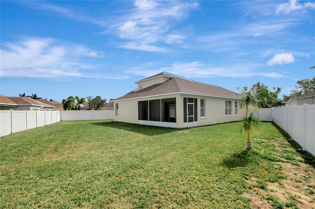 back of property with a sunroom and a lawn