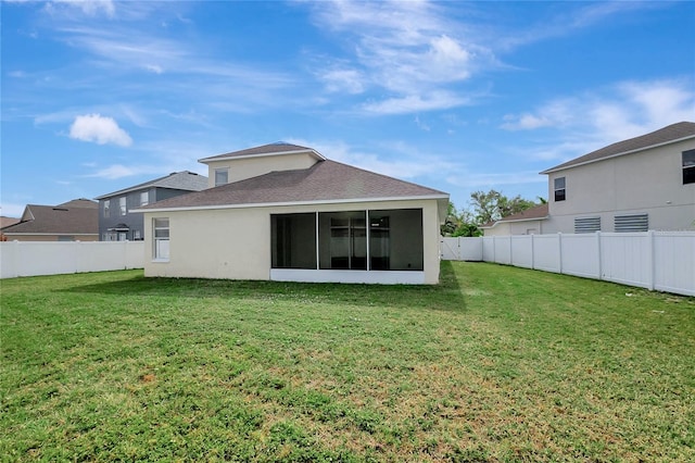 back of property featuring a lawn and a sunroom